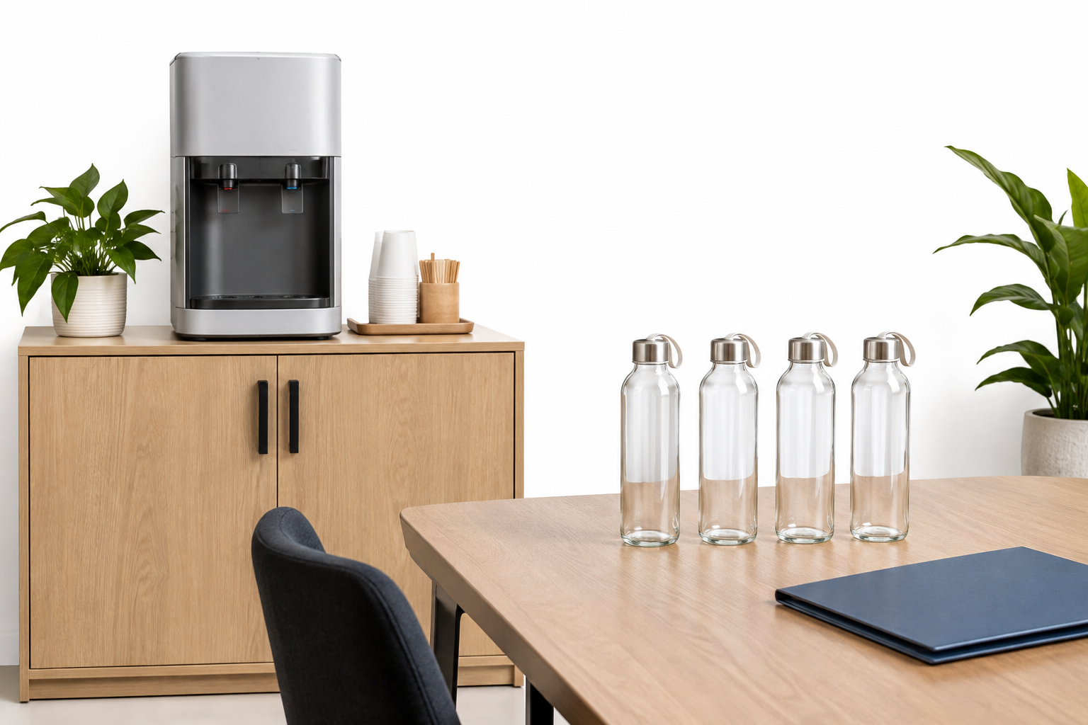Illustrative Wasserstation in einer Büroküche mit vier wiederverwendbaren Trinkflaschen.